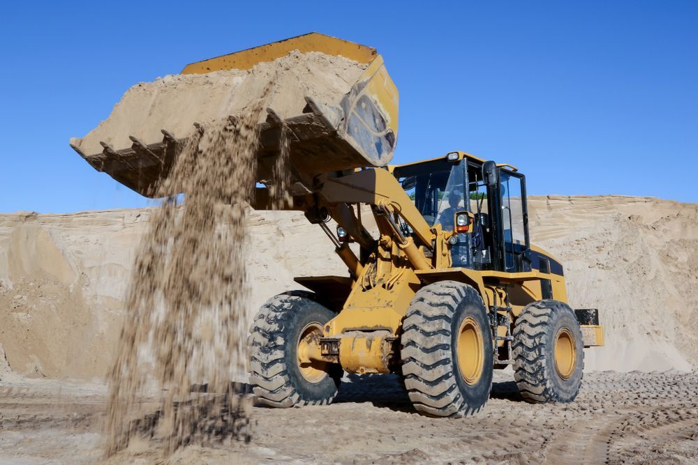 A Bulldozer is Pouring Sand Into a Pile — Hothams In Mudgee, NSW