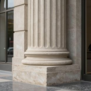A light-colored stone column with vertical fluting, resting on a square base beside a glass storefront.