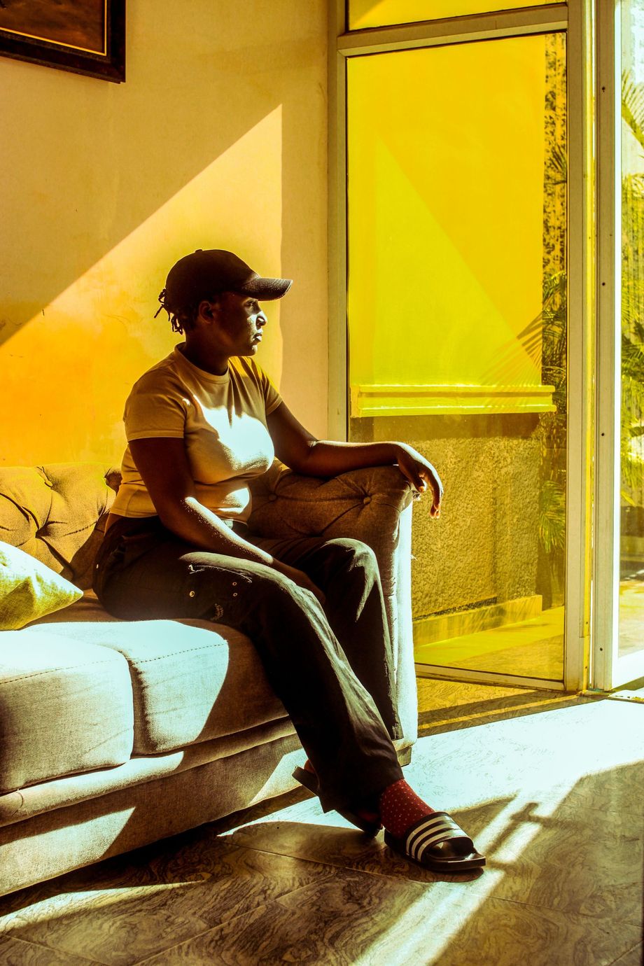 Woman sitting thoughtfully in a sunlit room reflecting and taking time for herself