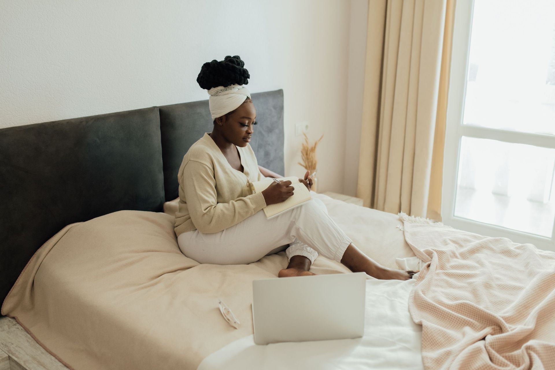 Woman journaling in natural light while reflecting on boundaries and self-care