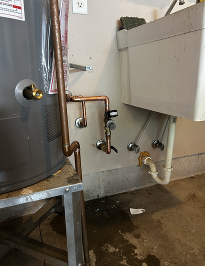 Technician inspecting a wall-mounted water heater in a bright home utility room
