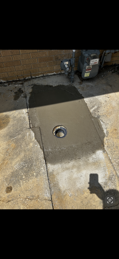 Gloved hands unclogging a stainless steel kitchen sink drain with a drain snake