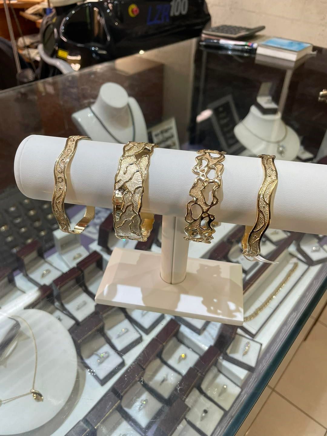 Four Gold Bracelets Displayed on a White T-bar Stand — Chris Williams Retail & Manufacturing Jewellers in Wanguri, NT