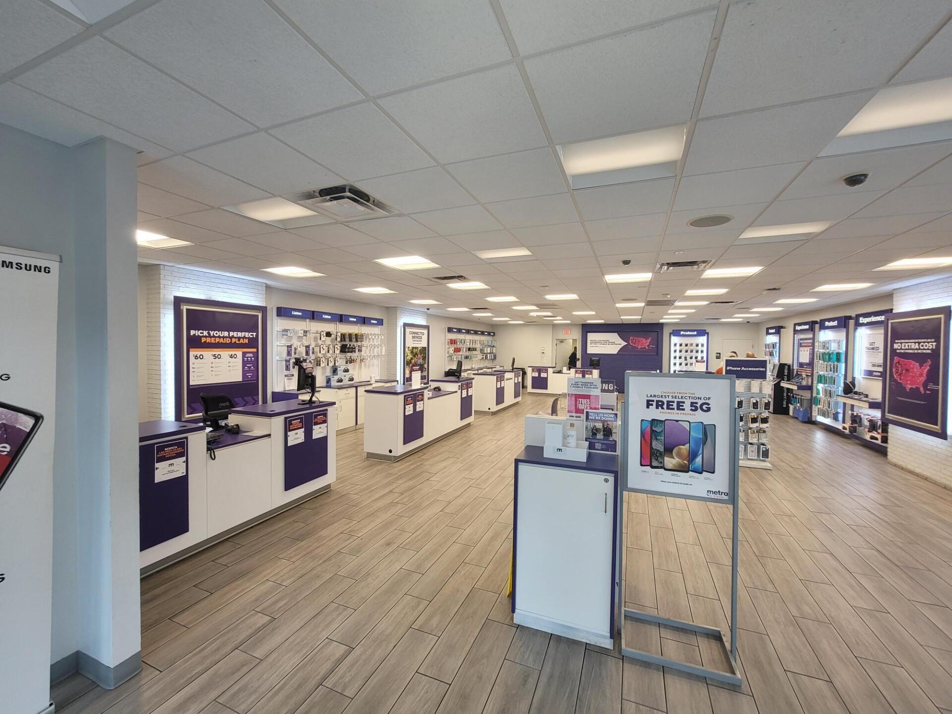 Interior of a retail store with displays, posters, and multiple check-out counters, all with purple accents.