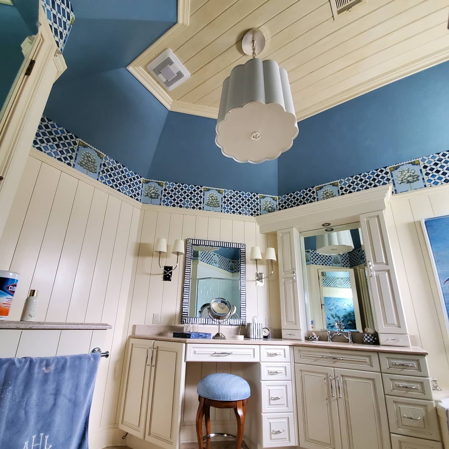 Bathroom with blue ceiling, white walls, vanity, and decorative tiles.