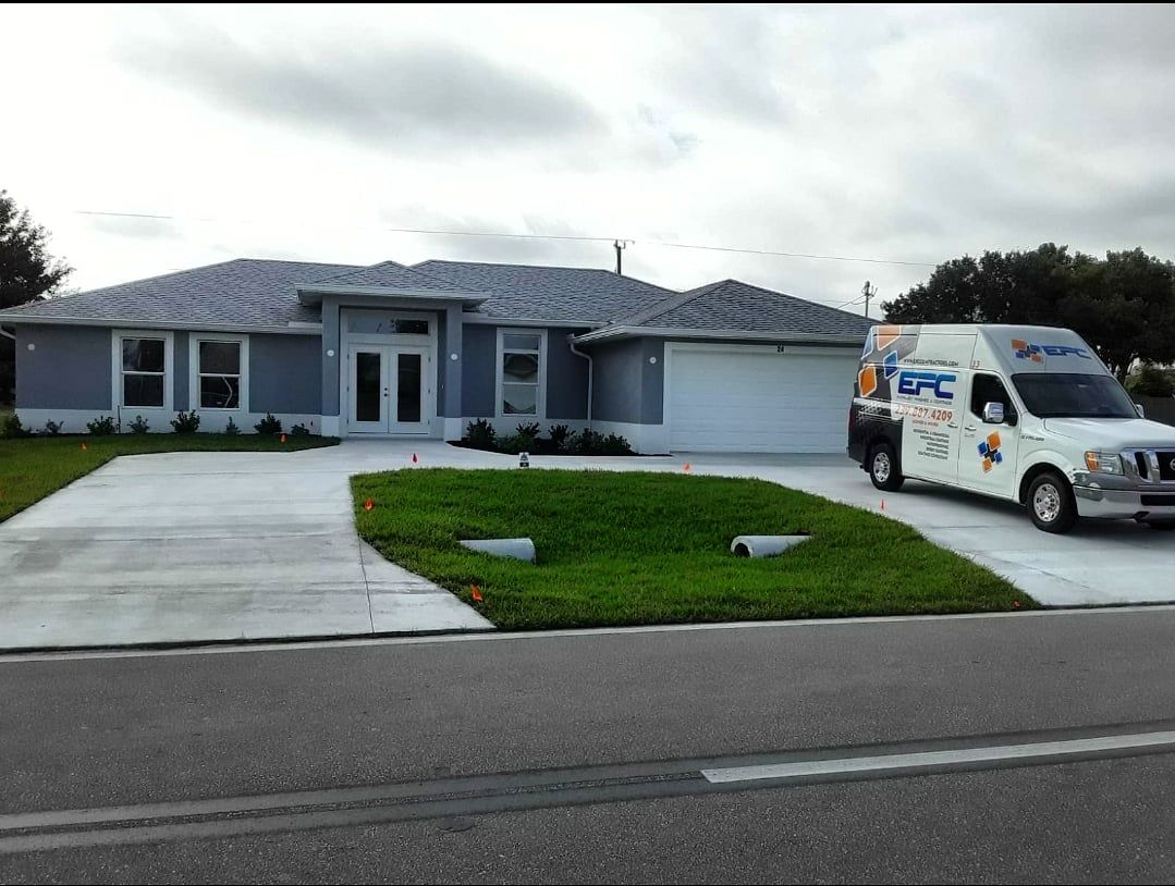 Gray house with a white garage, driveway, and van parked on the right.