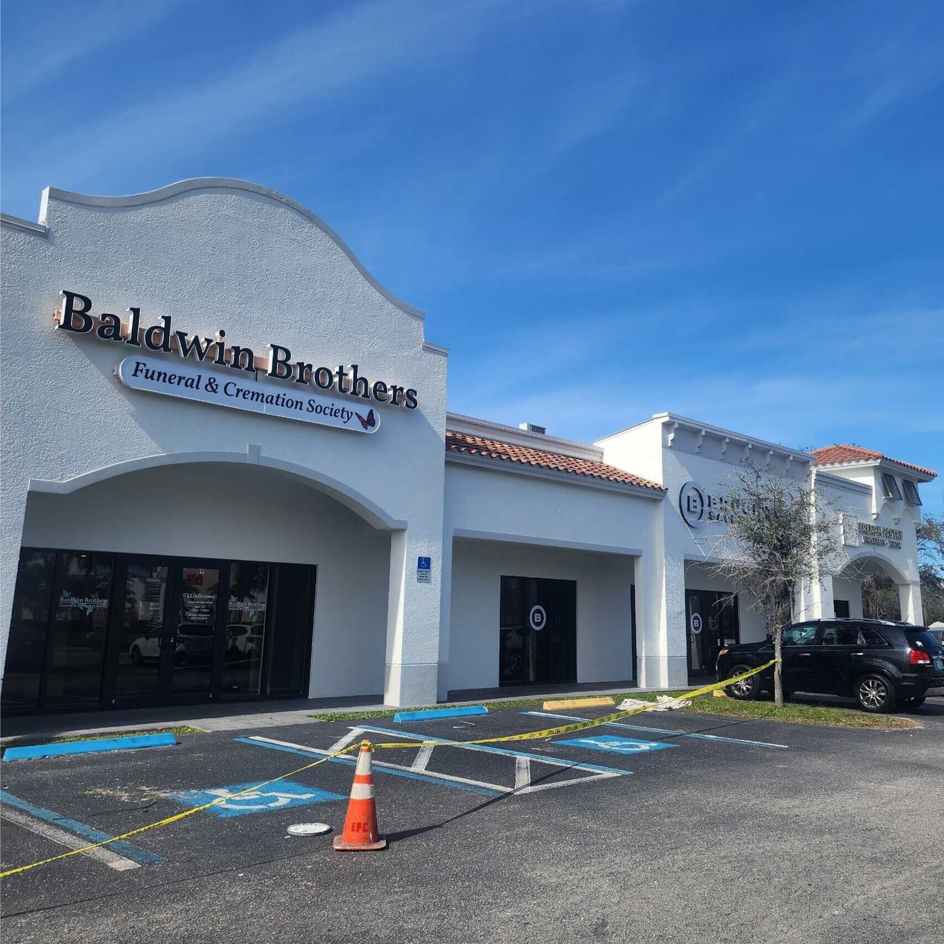 Exterior of Baldwin Brothers restaurant in a white building, blue sky.
