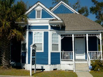 Blue and white Victorian house with porch, windows, and gabled roof.