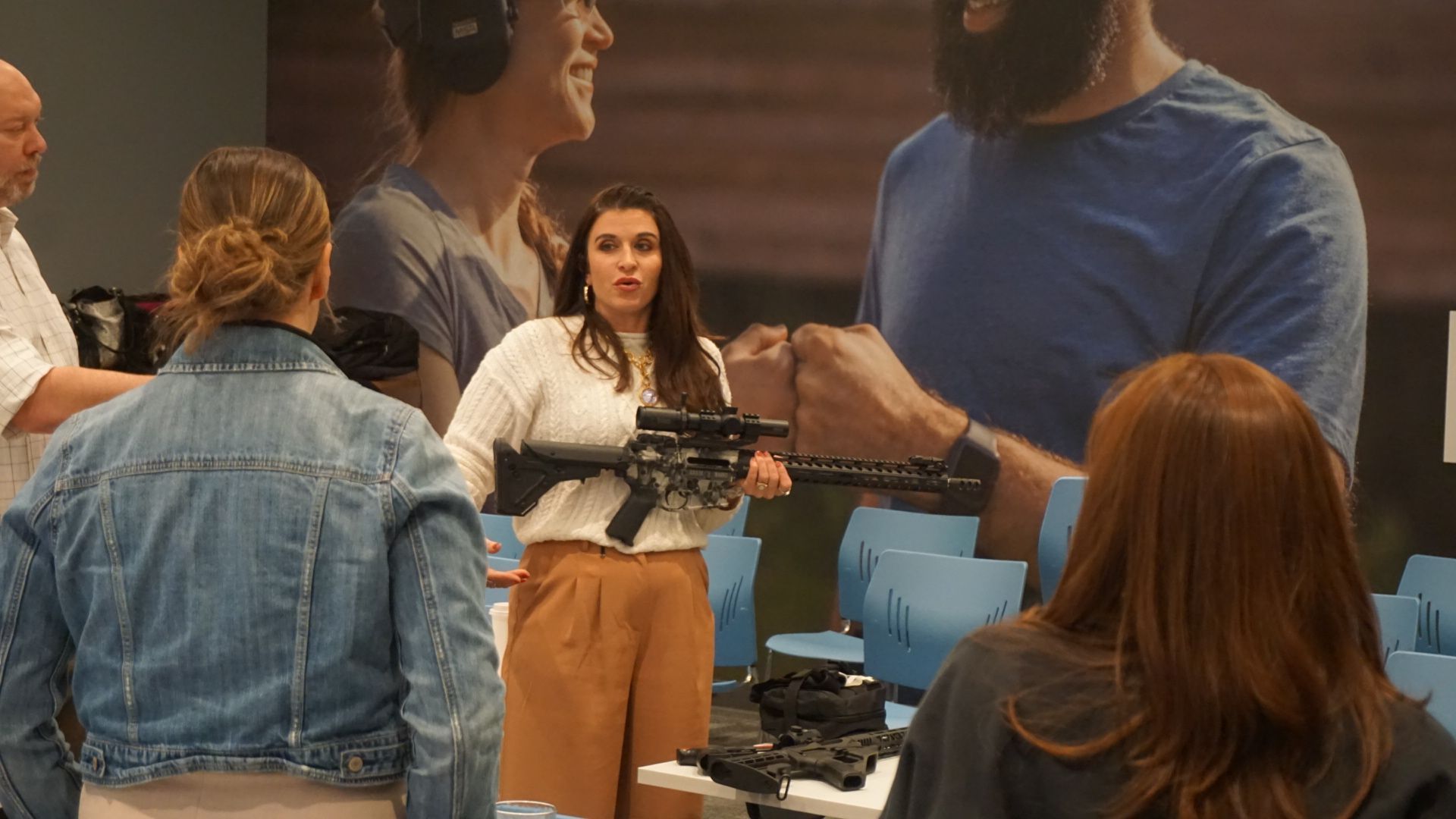 People gathered around a display, with a woman standing behind a mounted camera or equipment.