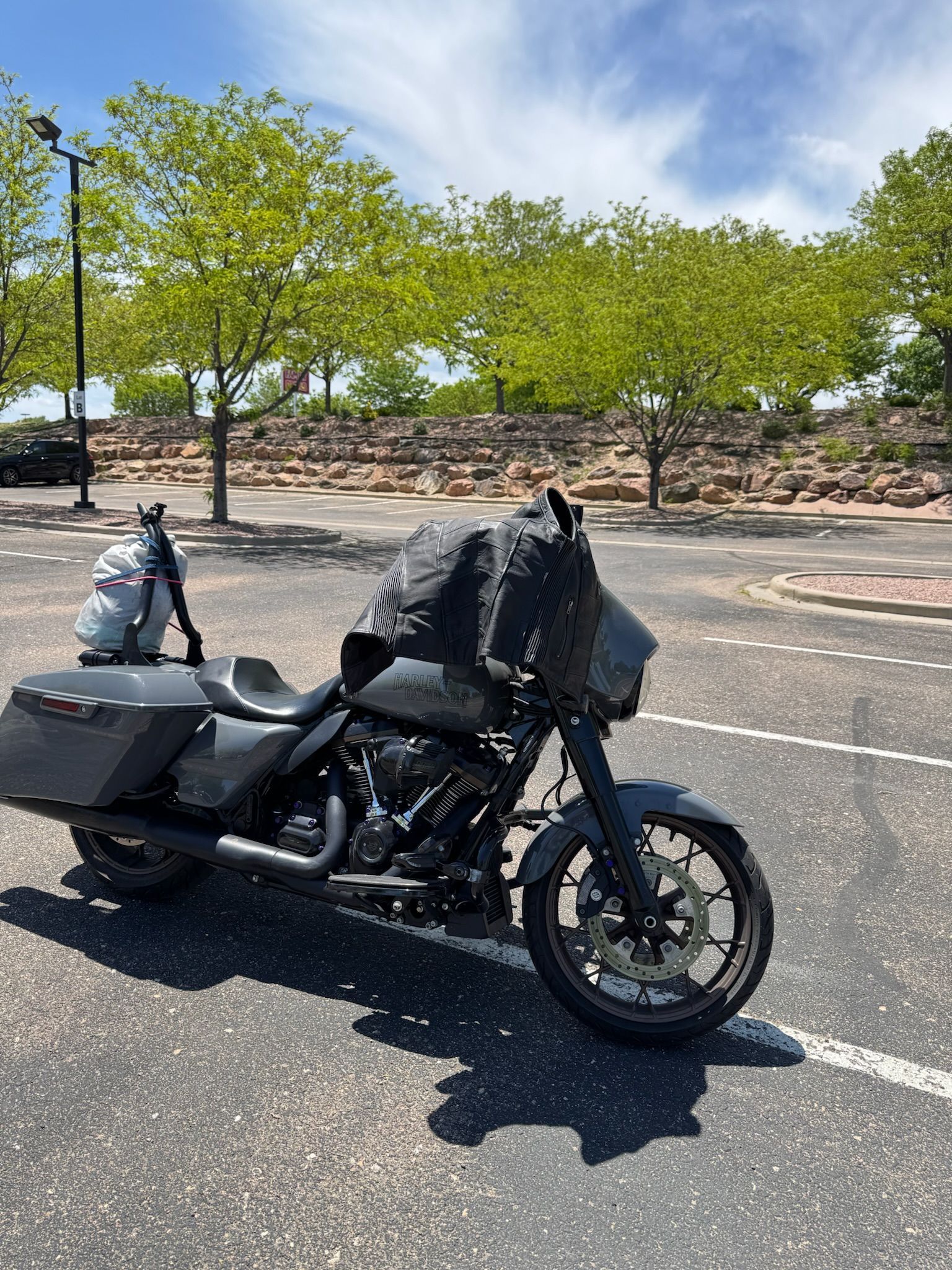 A motorcycle is parked on the side of the road in a parking lot.