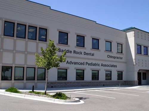 Dental clinic building exterior with signage for Saddle Rock Dental and Advanced Pediatric Associates