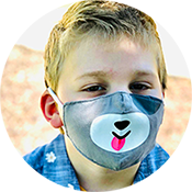 Young child wearing a gray bear-face mask, looking at the camera.