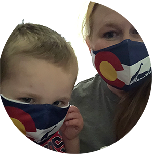 Two people wearing Colorado flag face masks, close together against a white background