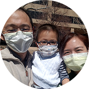 Three people wearing masks posing for a selfie outdoors in sunlight