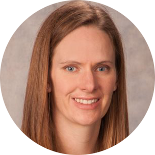 Headshot of a smiling person with straight light brown hair on a neutral background