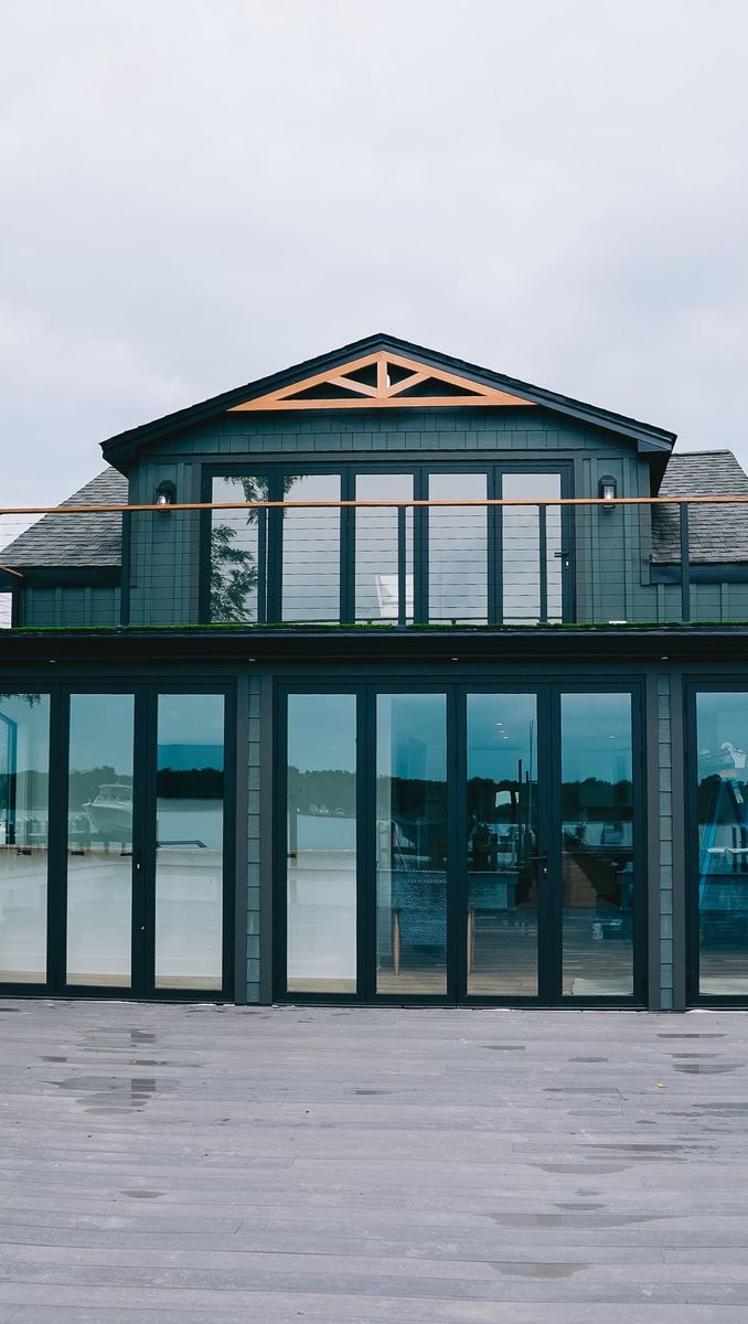 Modern beach house with large glass doors and balcony facing the ocean