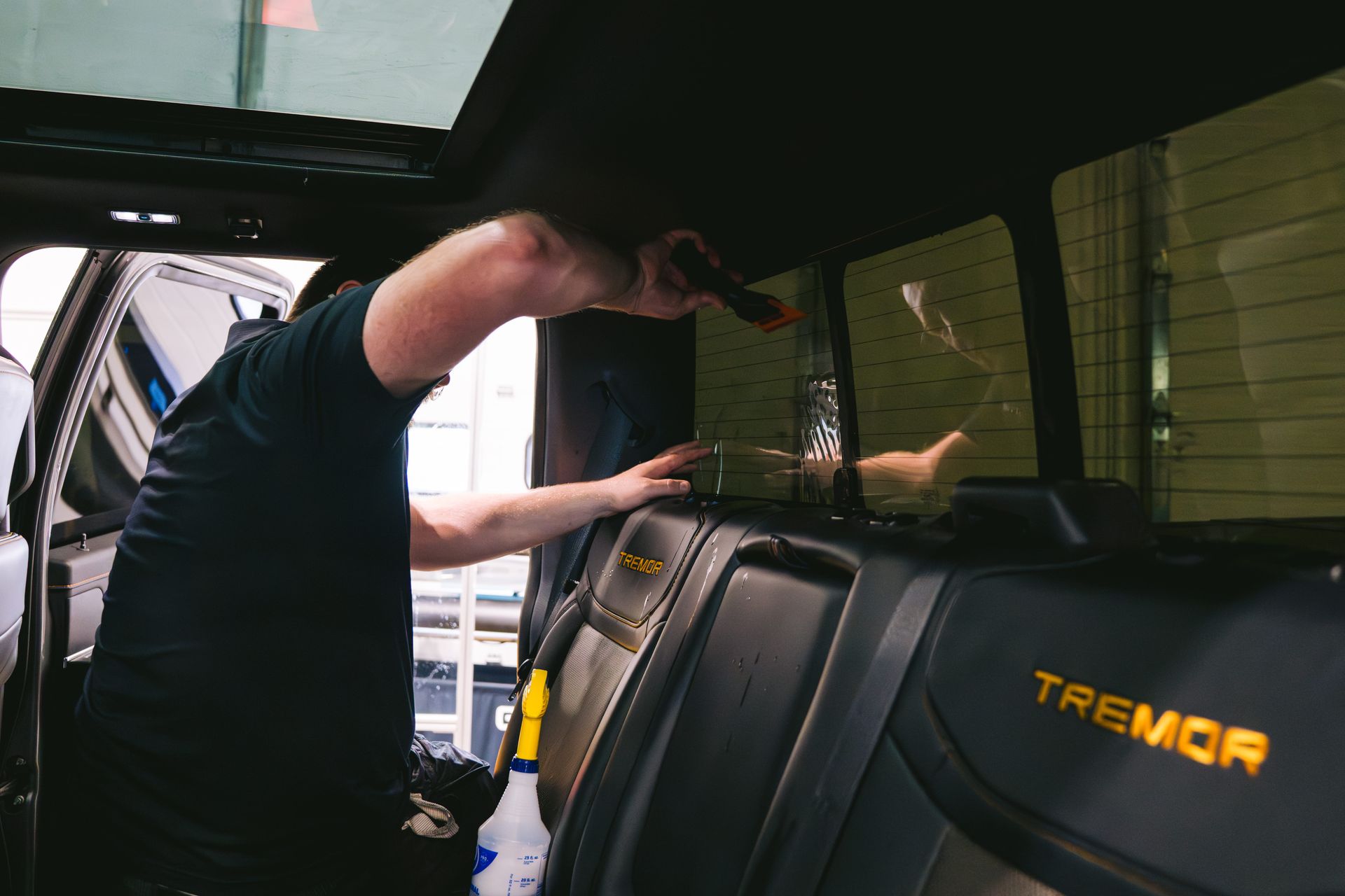 Person leaning into the back of a black Tremor truck under a canopy