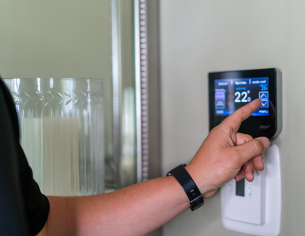 ottawa HVAC technician adjusting thermostat