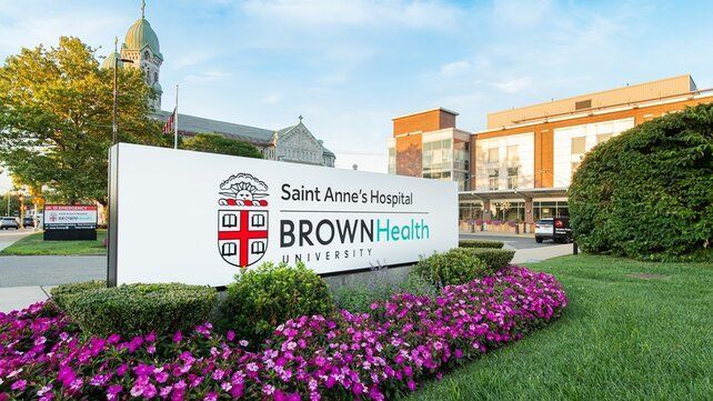 Saint Anne’s Hospital Brown Health sign in front of flowers and hospital buildings