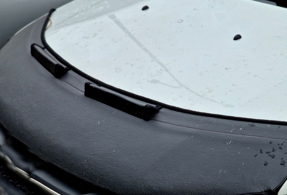 Close-up of a gray Dodge car front grille and headlights against a dark background