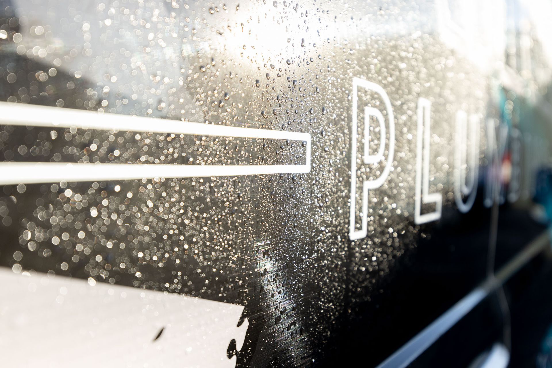 A platinum plumbing truck is parked in a parking lot