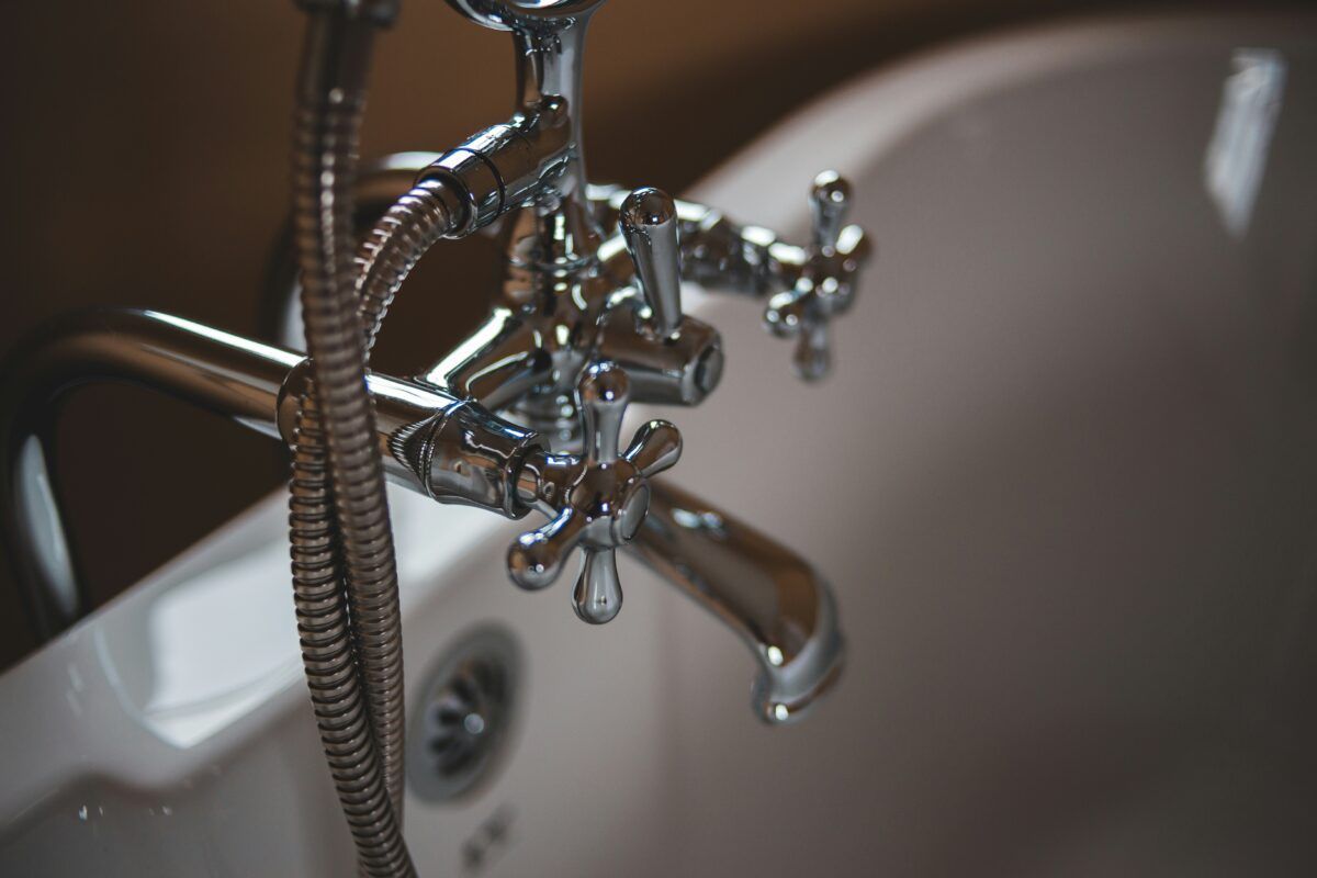 A close up of a bathtub with a shower head attached to it.