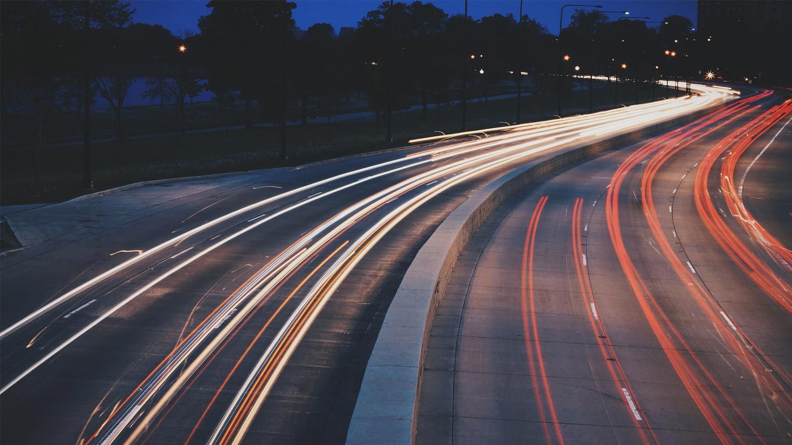 Ein Langzeitbelichtungsfoto einer Autobahn bei Nacht.