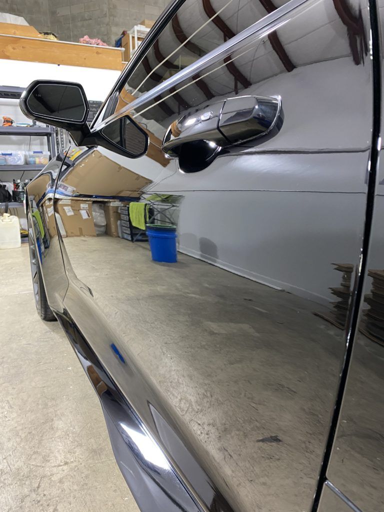 A black car is parked in a garage.