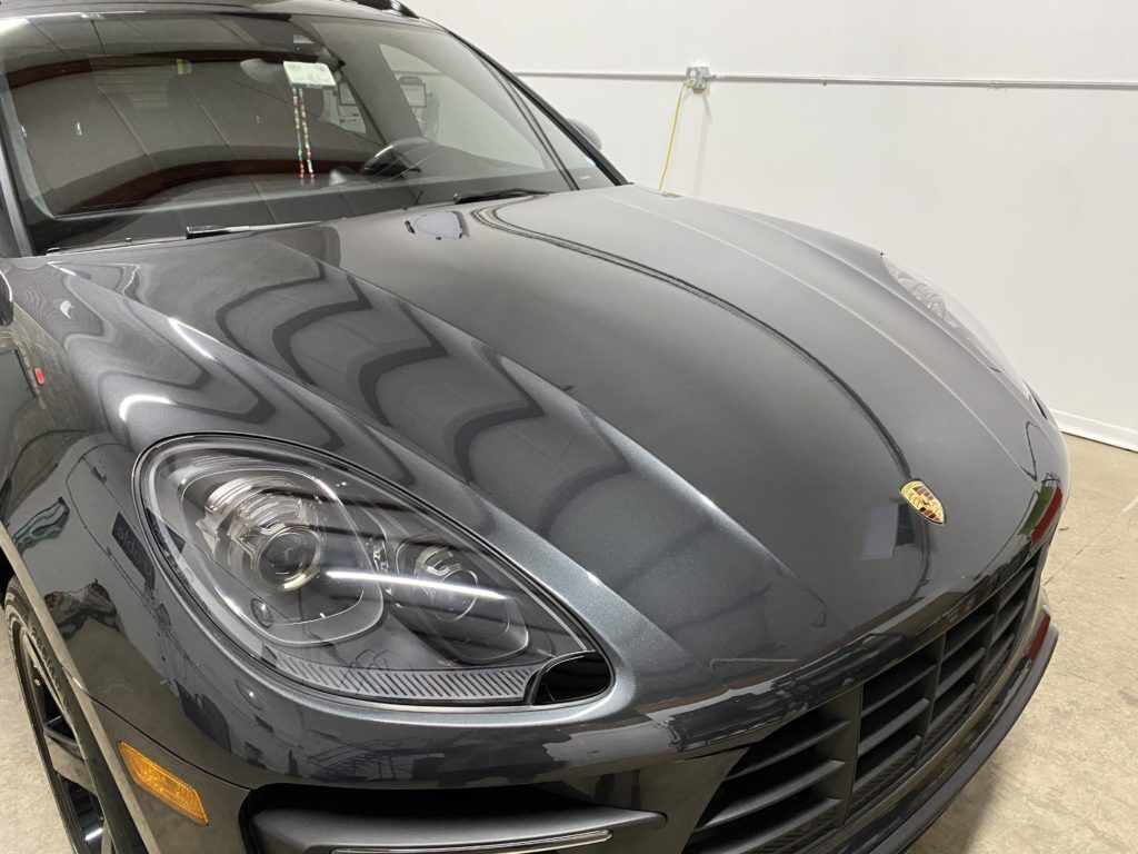 A black porsche macan is parked in a garage.