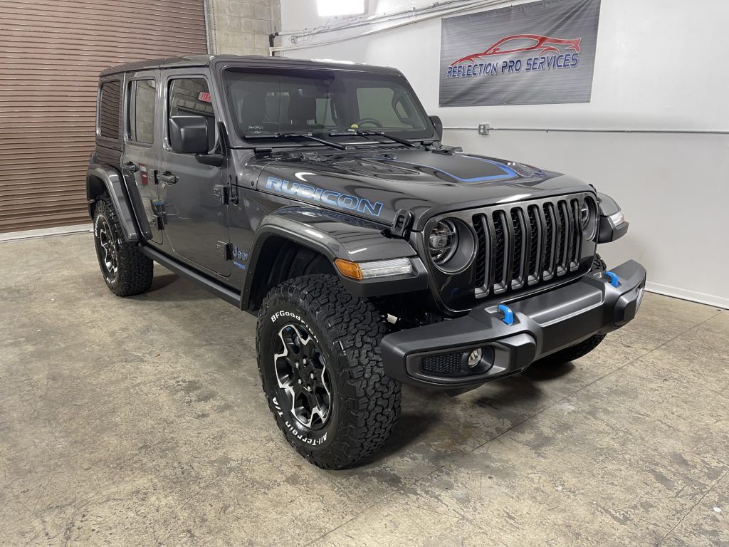 A gray jeep wrangler is parked in a garage.