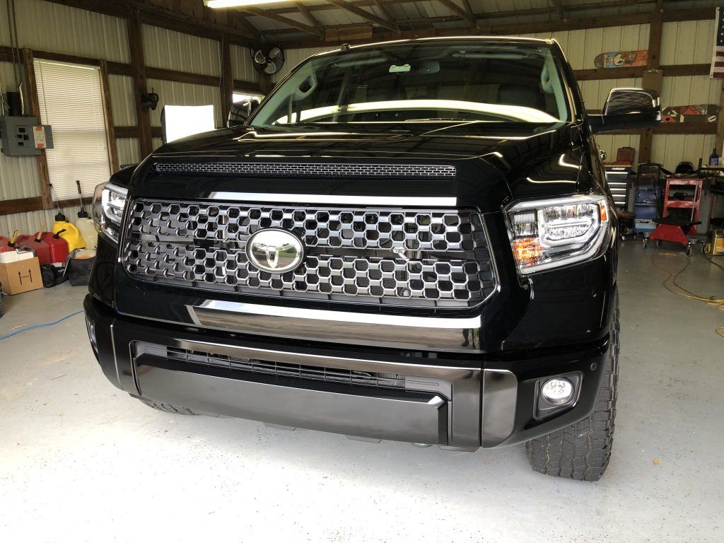 A black toyota tundra is parked in a garage.