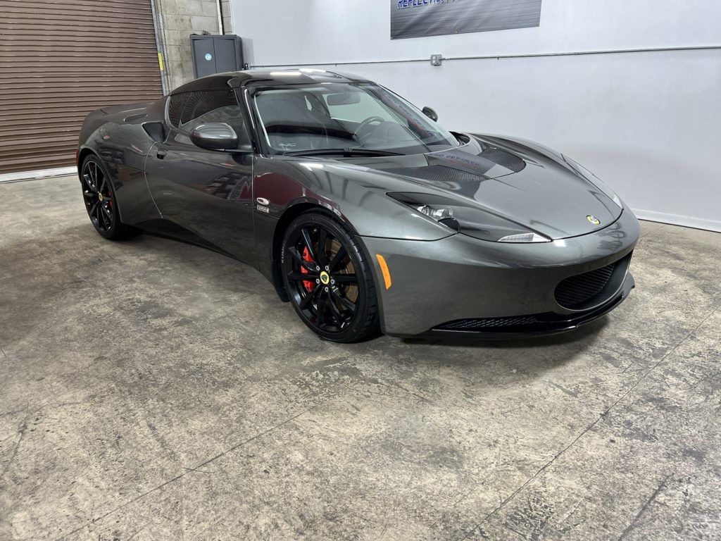 A gray sports car is parked in a garage.