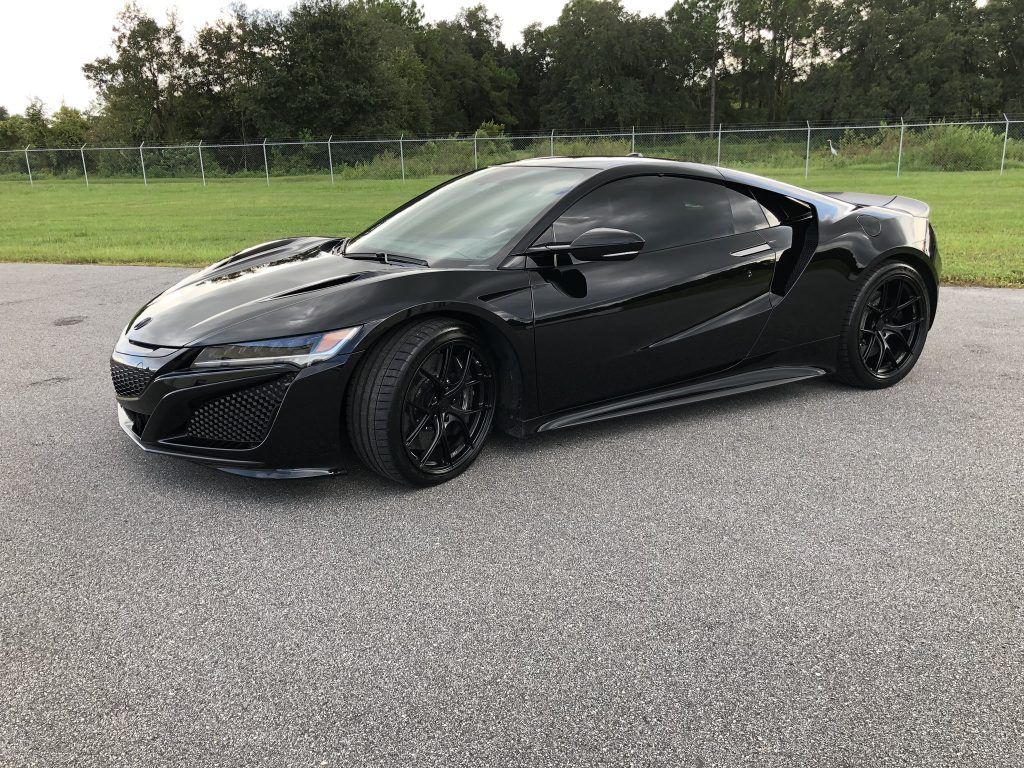 A black sports car is parked on the side of the road.