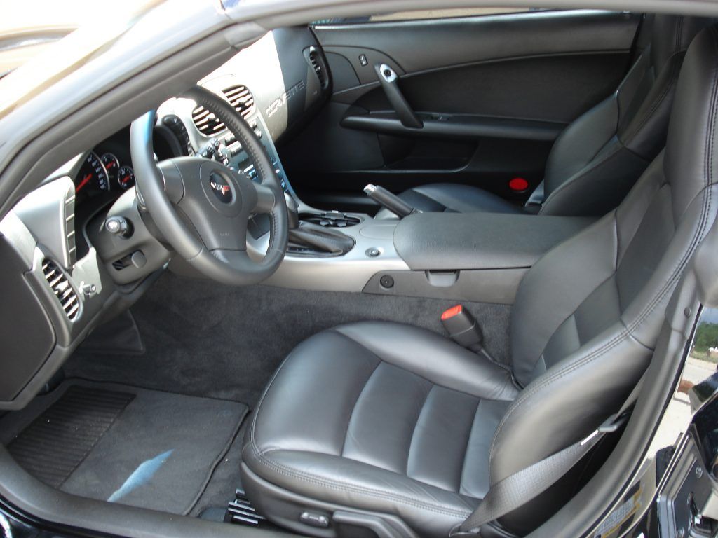 The interior of a black sports car with the door open