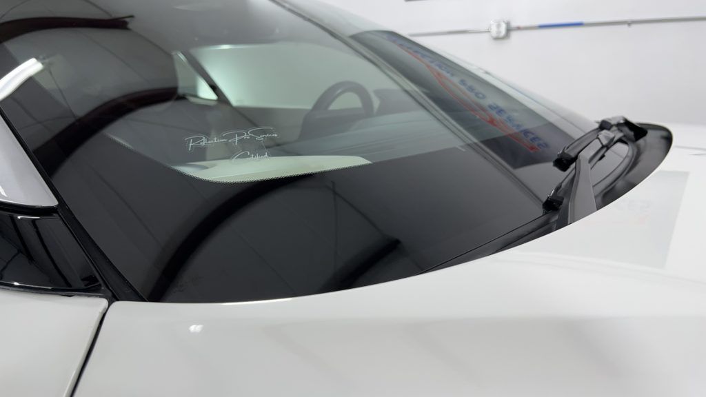 A close up of a car windshield with a wiper on it.
