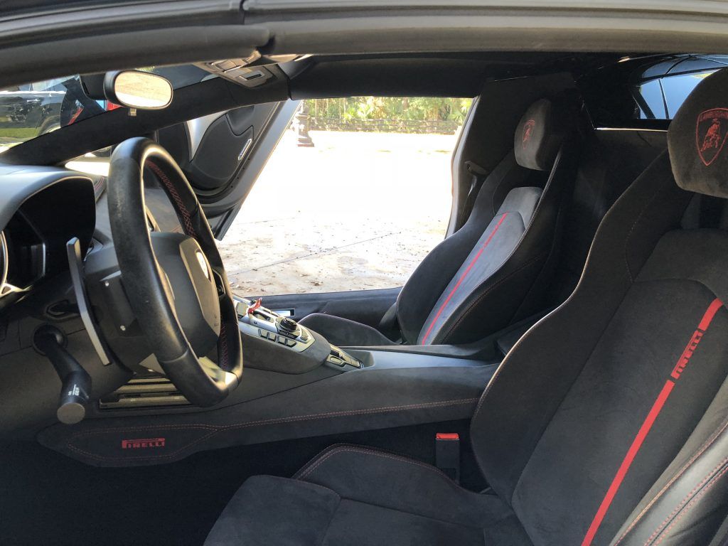 The interior of a sports car with a steering wheel and seats.