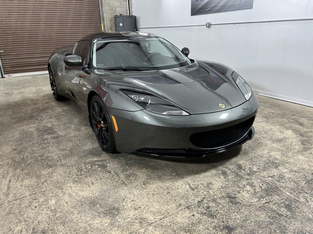 A gray sports car is parked in a garage.