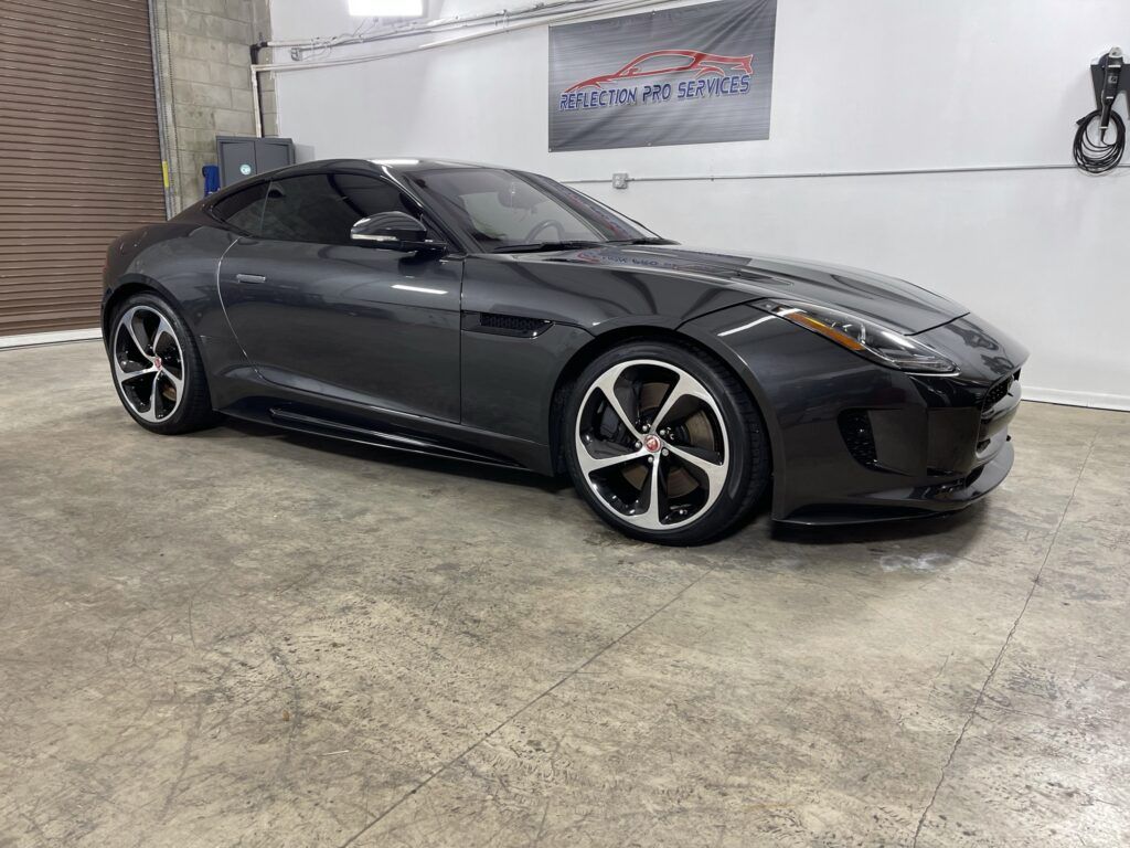 A jaguar f type is parked in a garage.