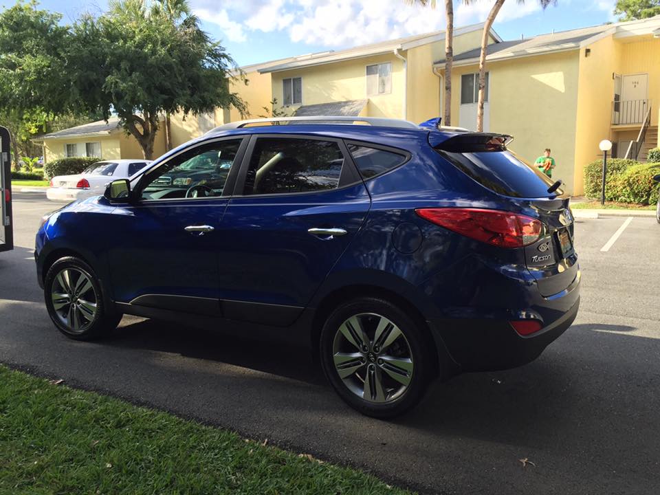 A blue suv is parked in a parking lot in front of a building