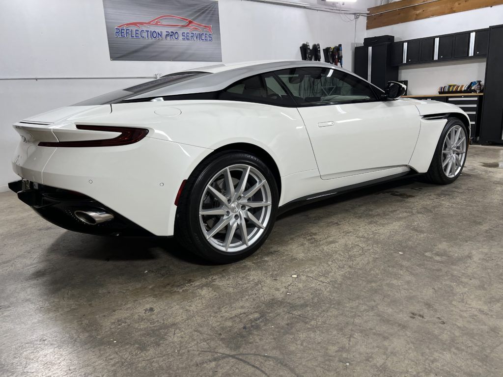 A white sports car is parked in a garage.