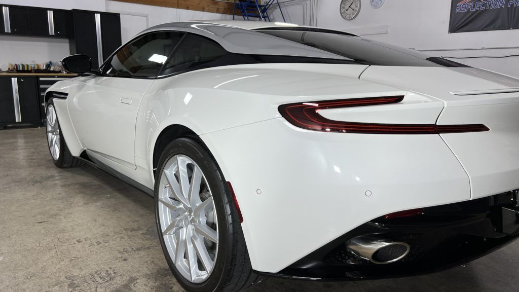 A white sports car is parked in a garage.