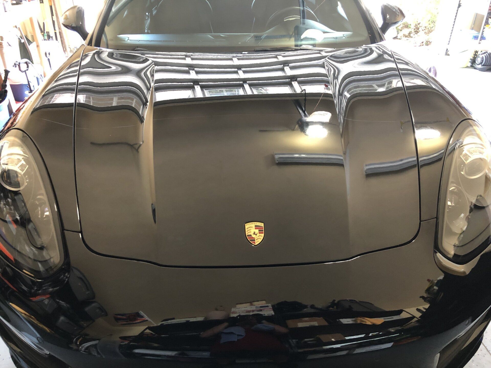 A black porsche cayenne is parked in a garage.