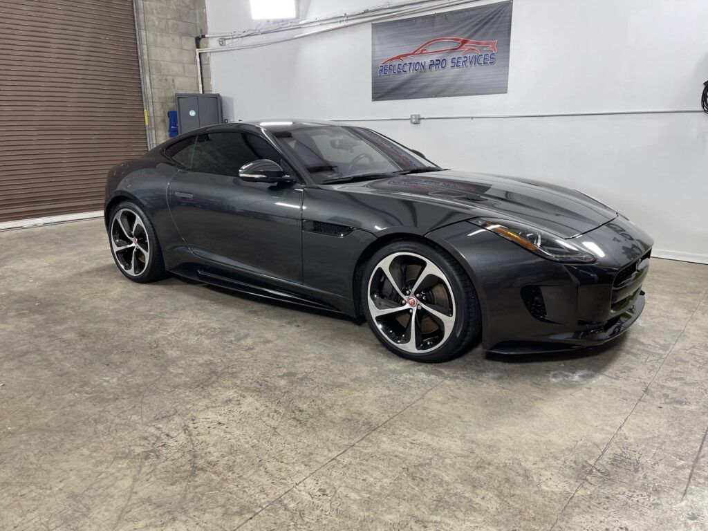 A jaguar f type is parked in a garage.