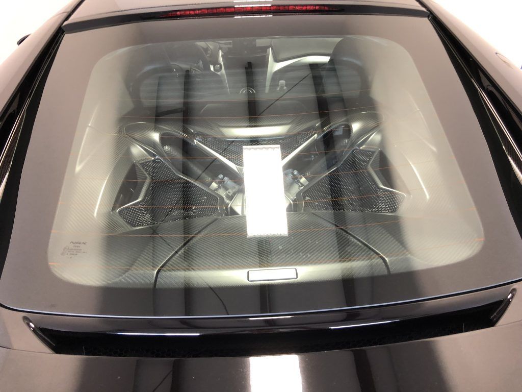 A close up of the hood of a car showing the engine