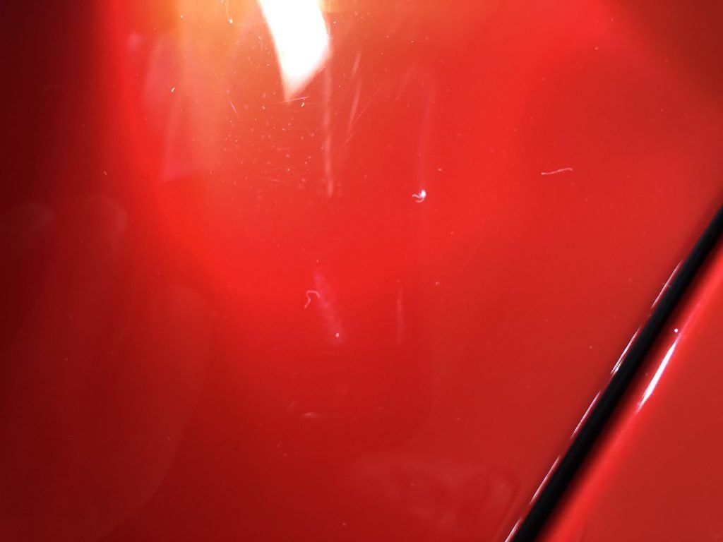 A close up of a red car with a light shining on it