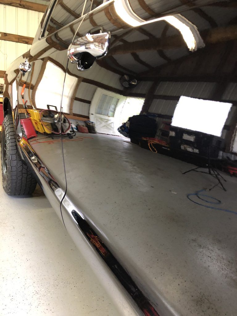 A black truck is parked in a garage.
