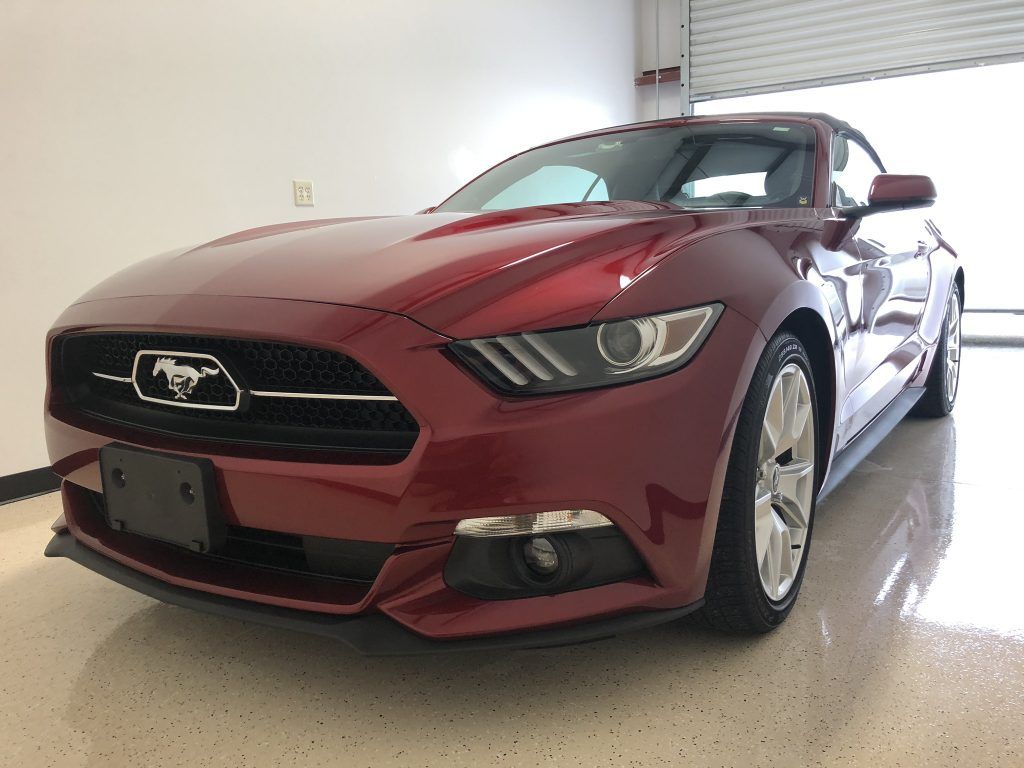 A red ford mustang is parked in a garage.