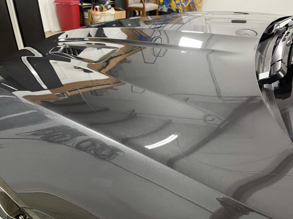 A close up of the hood of a car in a garage.