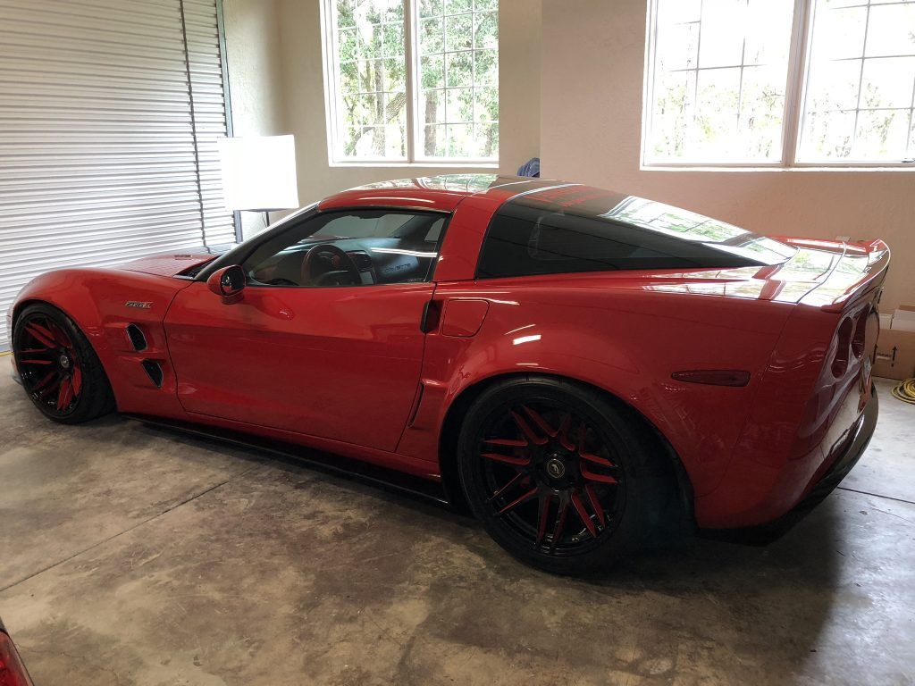A red sports car is parked in a garage.