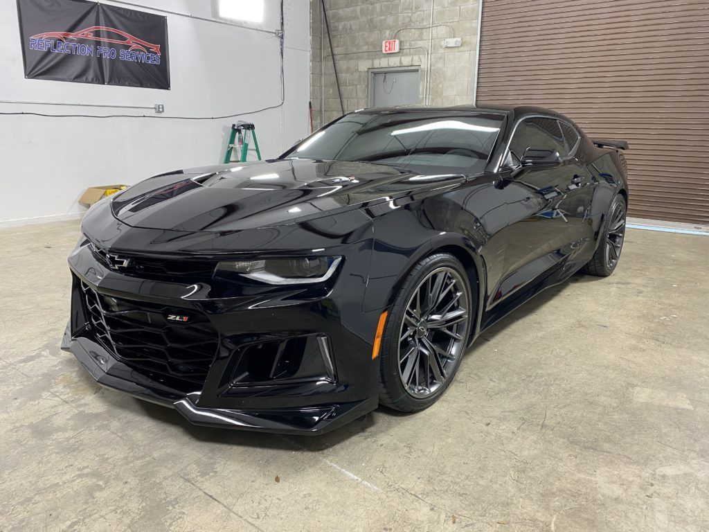 A black chevrolet camaro zl1 is parked in a garage.